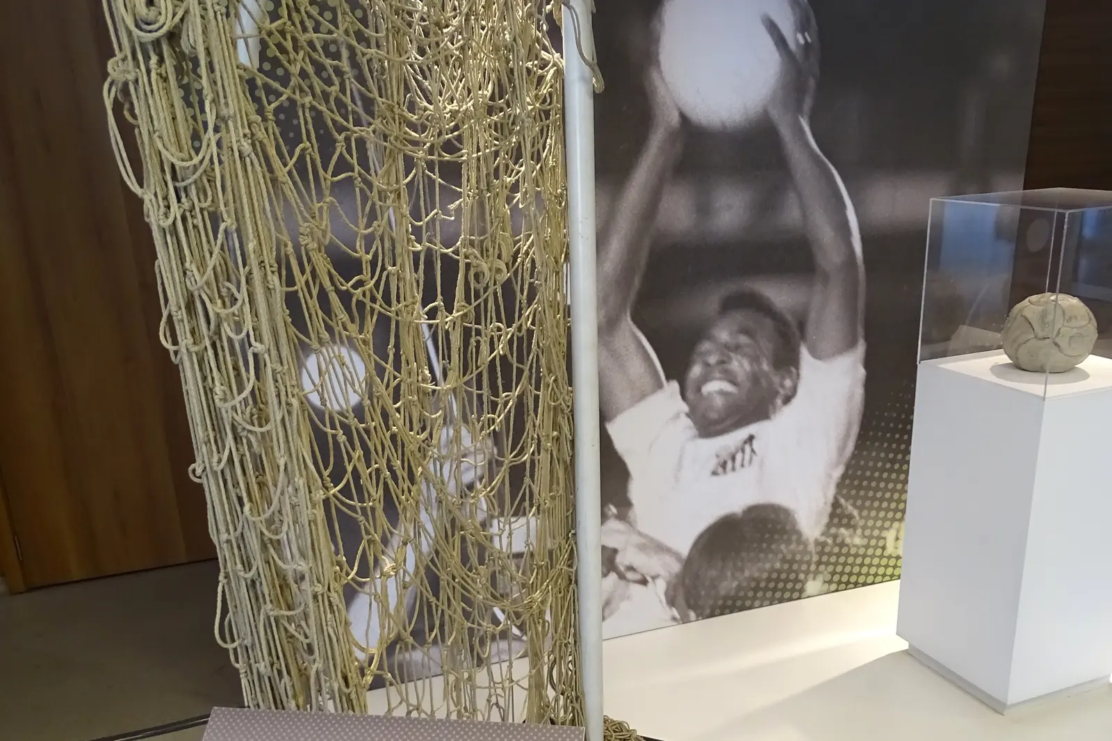 Una vetrina museale dedicata a Pelé, con una rete da calcio e una fotografia del giocatore accanto a un pannello informativo
