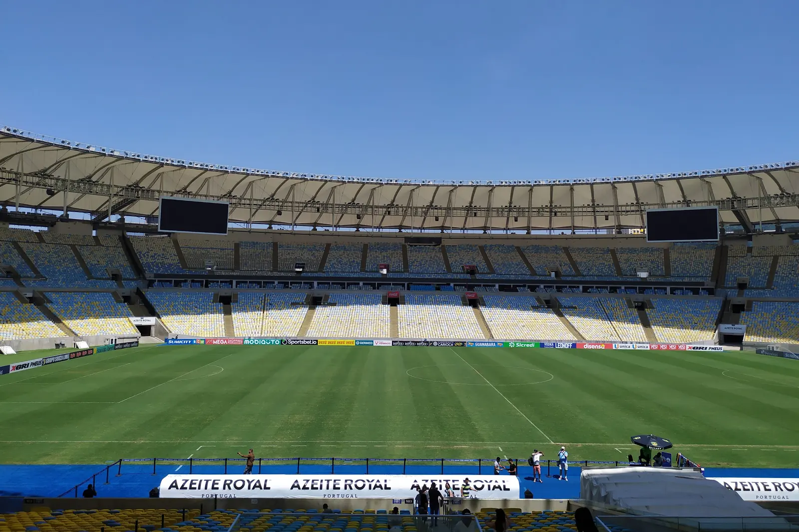 Il Maracanã visto da un posto nel settore superiore, con un campo verde sotto file di seggiolini gialli, blu e bianchi e un pallido anello del tetto sopra